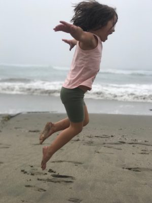 A Girl Jumping in the Sand