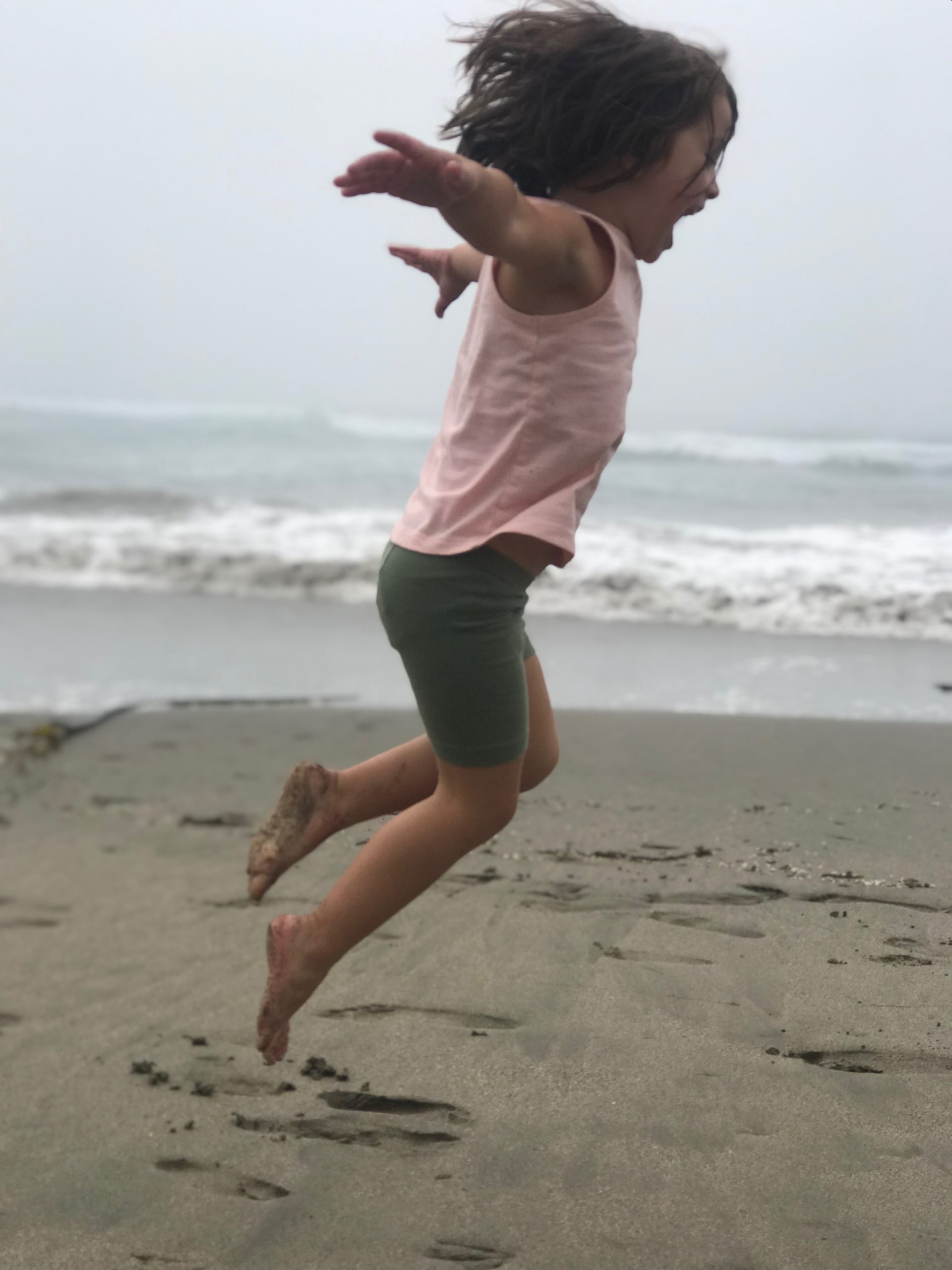 Girl jumping on the sand
